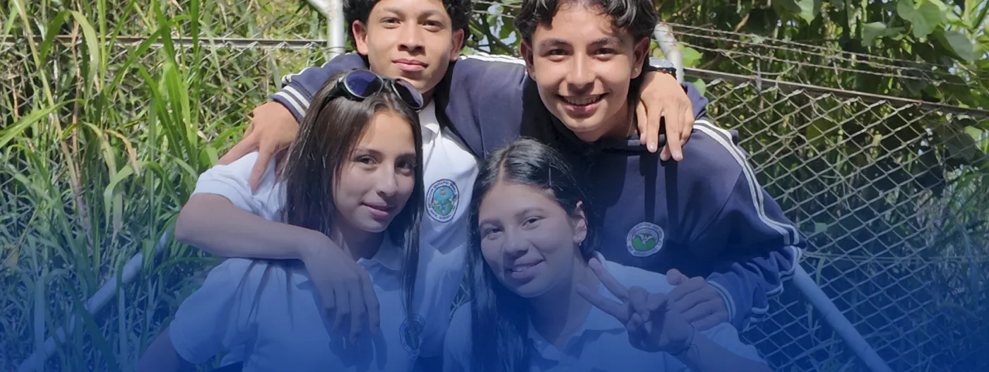 Grupo de 4 jóvenes abrazados en entorno escolar