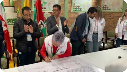 Fotografia de administrativos gubernamentales haciendo firma de un documento en un salón comunal