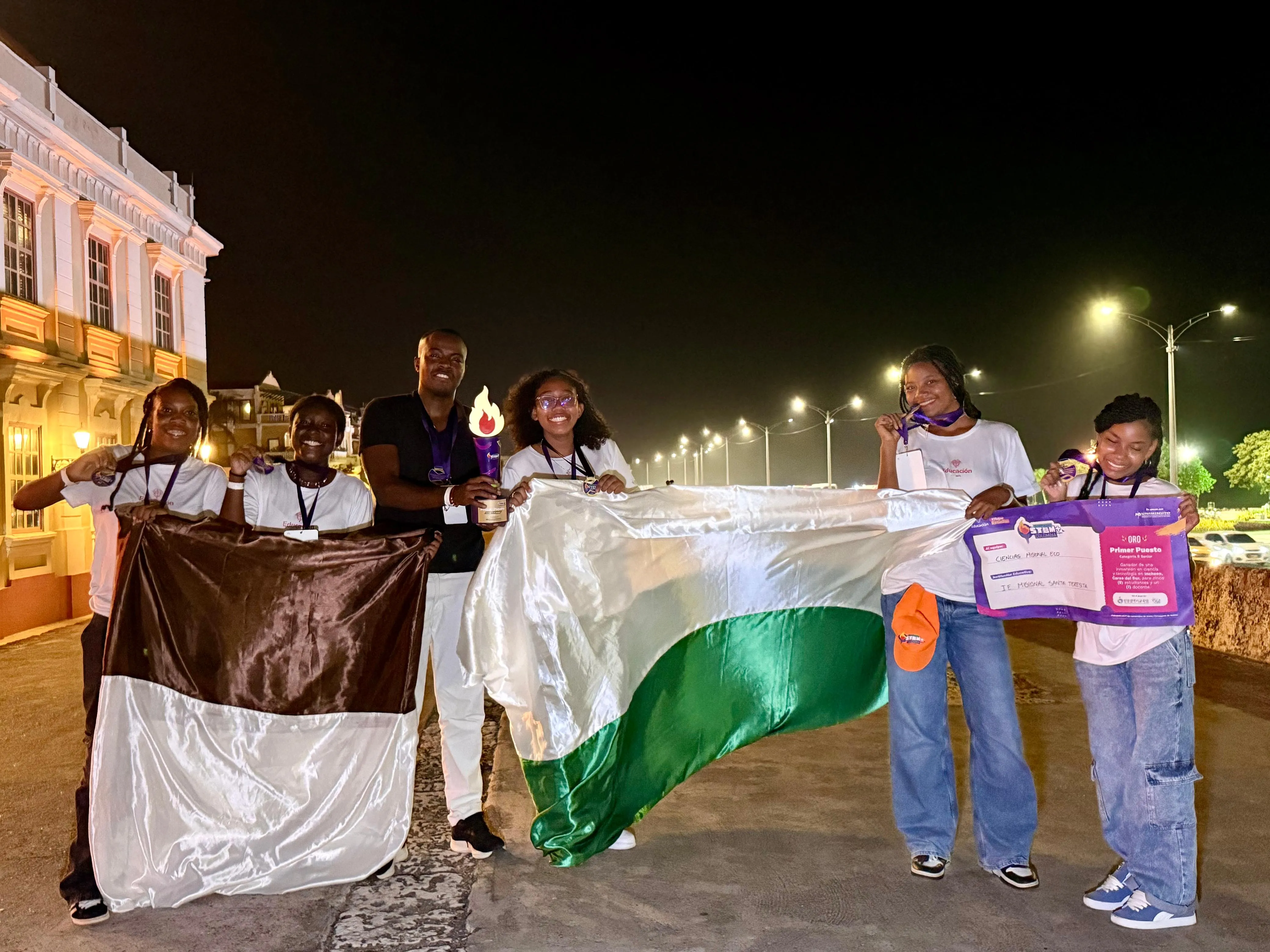 Imagen de 5 estudiantes y el docente con la bandera de Tumaco