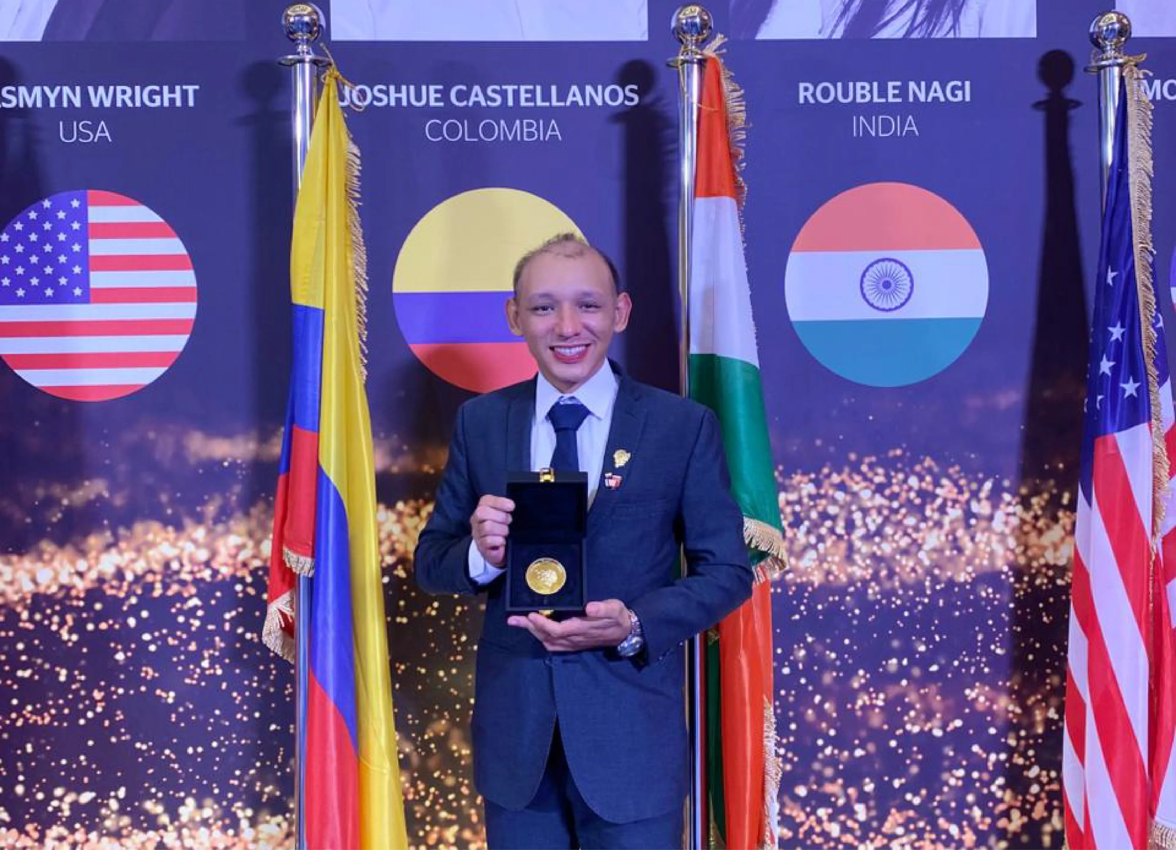 Profesor Joshua Castellanos mostrando la placa que lo certifica como uno de los 10 mejores profesores del mundo