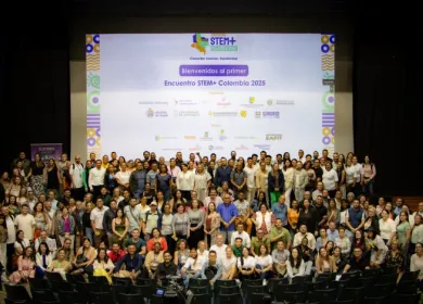Un gran número de personas en auditorio con el letrero de fondo que dice "Bienvenidos al primer encuentro STEM+ Colombia 2025" y los logos de los organizadores